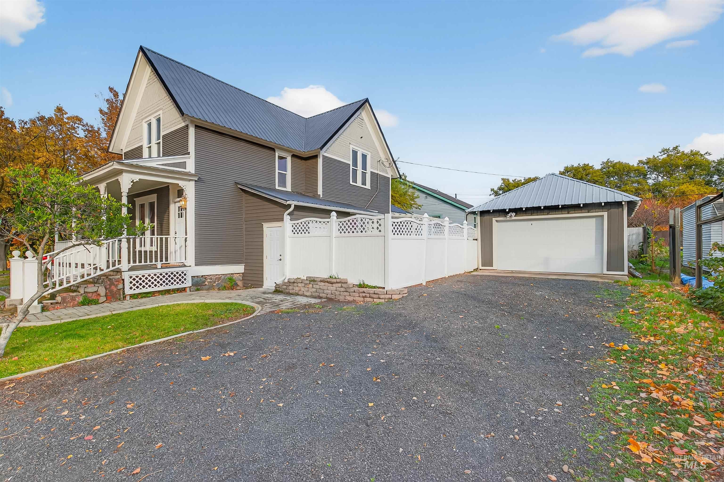302 7th Avenue Lewiston, ID 83501 - Photo 35 of 50 View of side of property with a porch, an outbuilding, a metal roof, a detached garage, and driveway