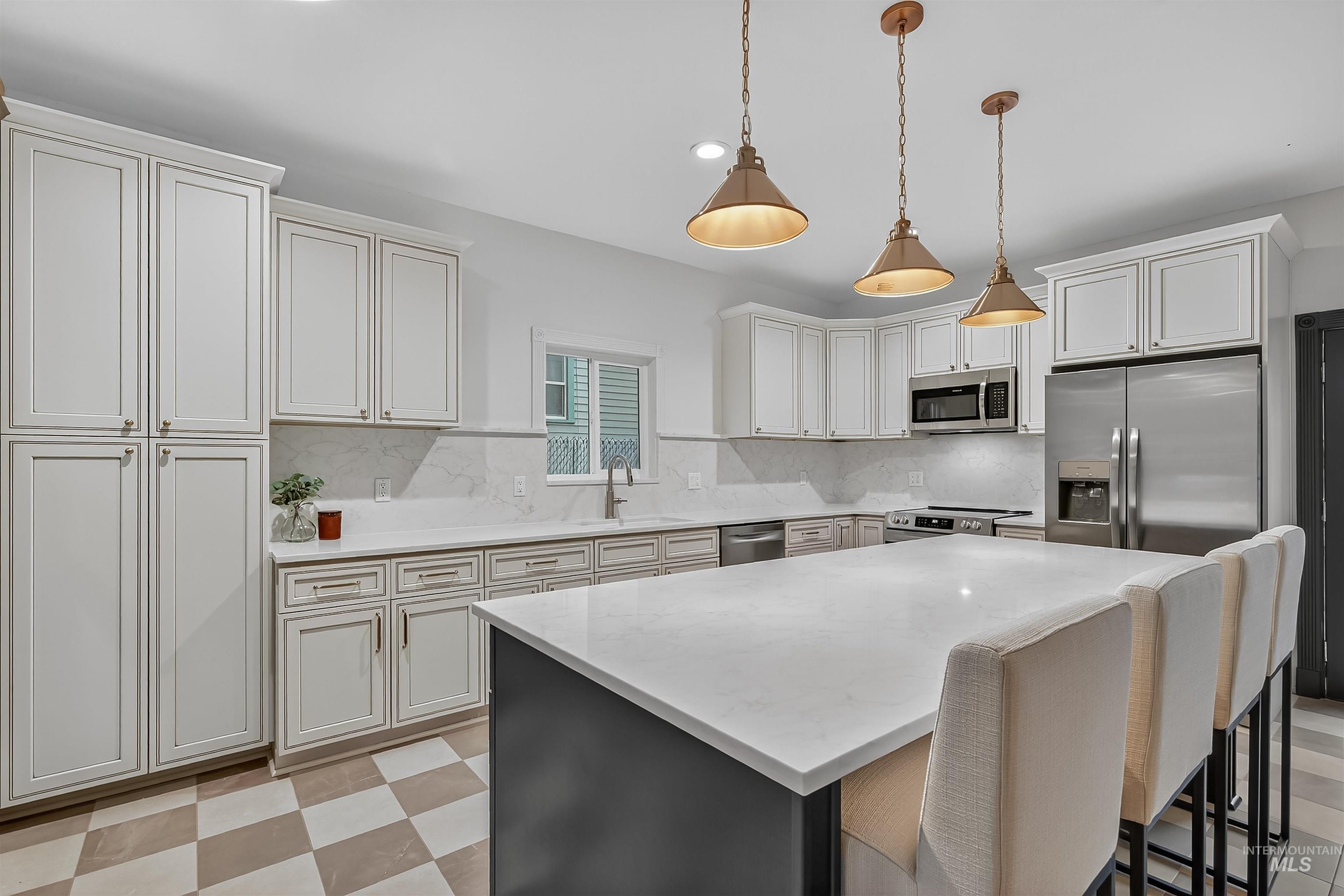 302 7th Avenue Lewiston, ID 83501 - Photo 5 of 50 Kitchen with stainless steel appliances, decorative backsplash, light stone counters, pendant lighting, and a kitchen island