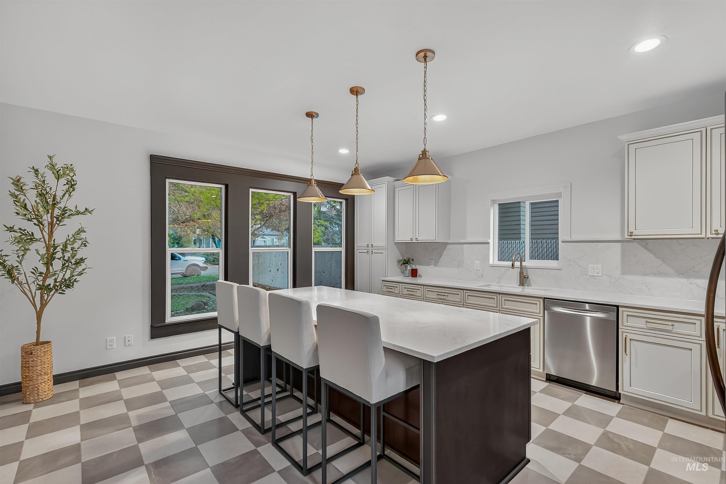 302 7th Avenue Lewiston, ID 83501 - Photo 7 of 50 Kitchen featuring light flooring, dishwasher, decorative backsplash, decorative light fixtures, and a kitchen bar