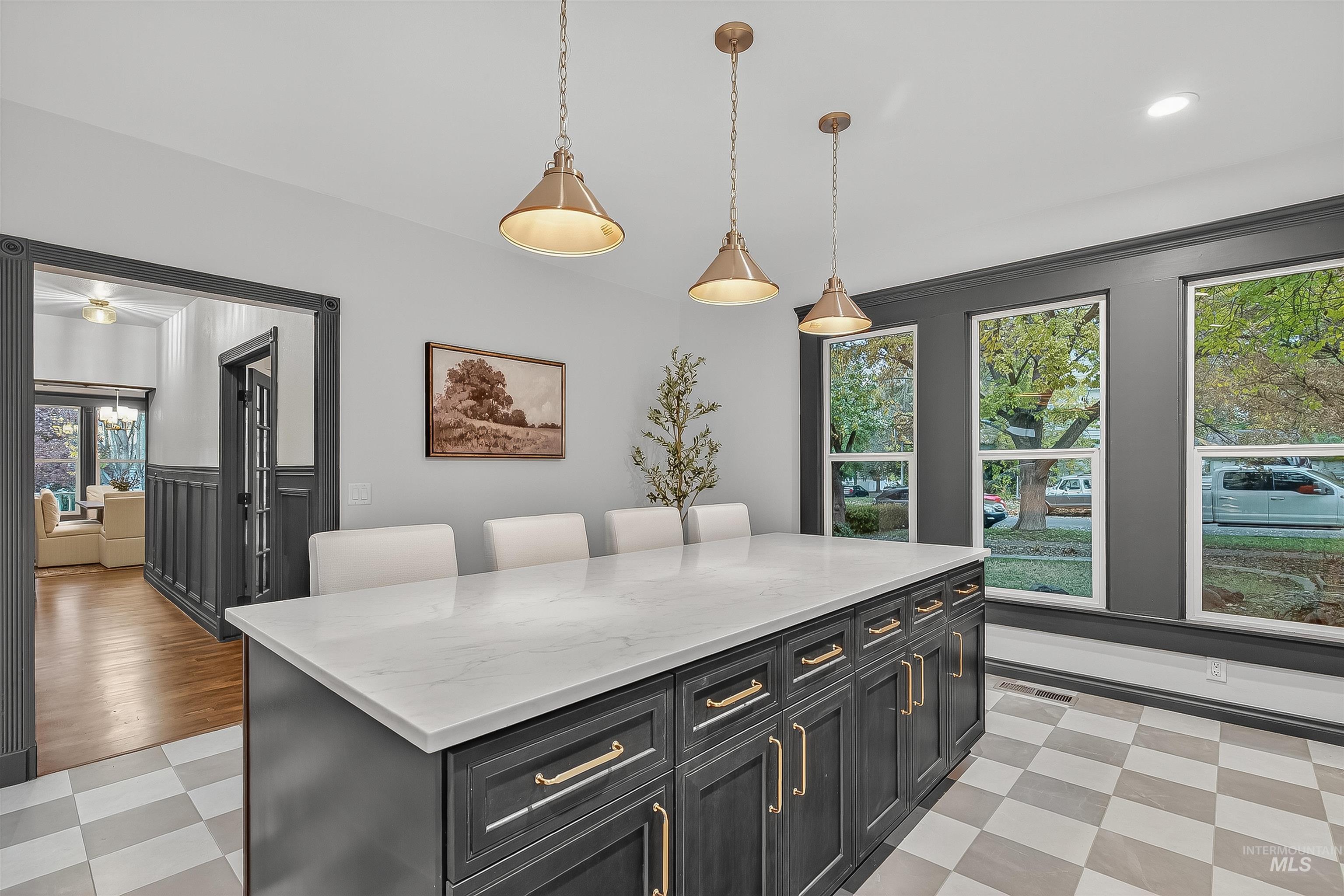 302 7th Avenue Lewiston, ID 83501 - Photo 8 of 50 Kitchen featuring dark cabinets, hanging light fixtures, light stone counters, light floors, and a breakfast bar area