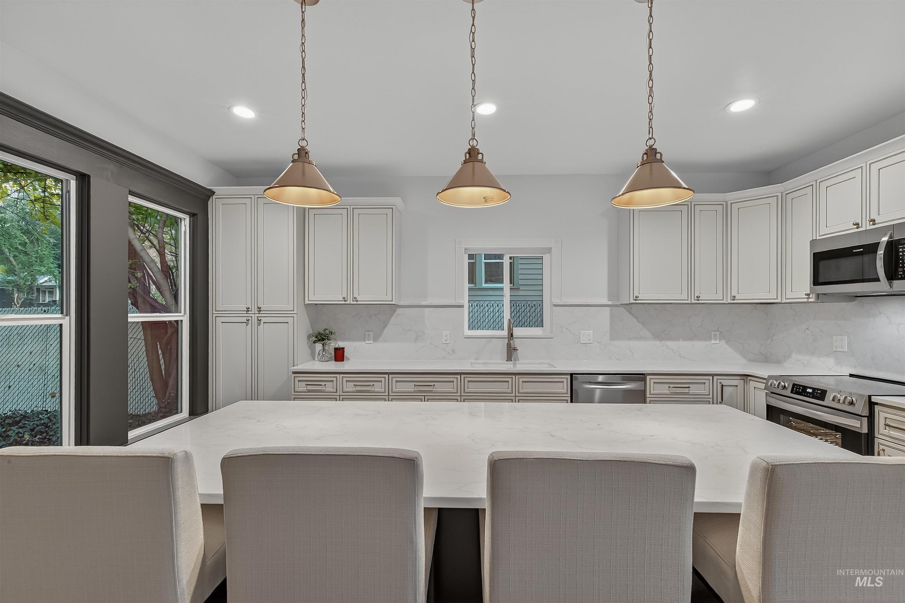 302 7th Avenue Lewiston, ID 83501 - Photo 10 of 50 Kitchen with a kitchen breakfast bar, tasteful backsplash, hanging light fixtures, appliances with stainless steel finishes, and recessed lighting