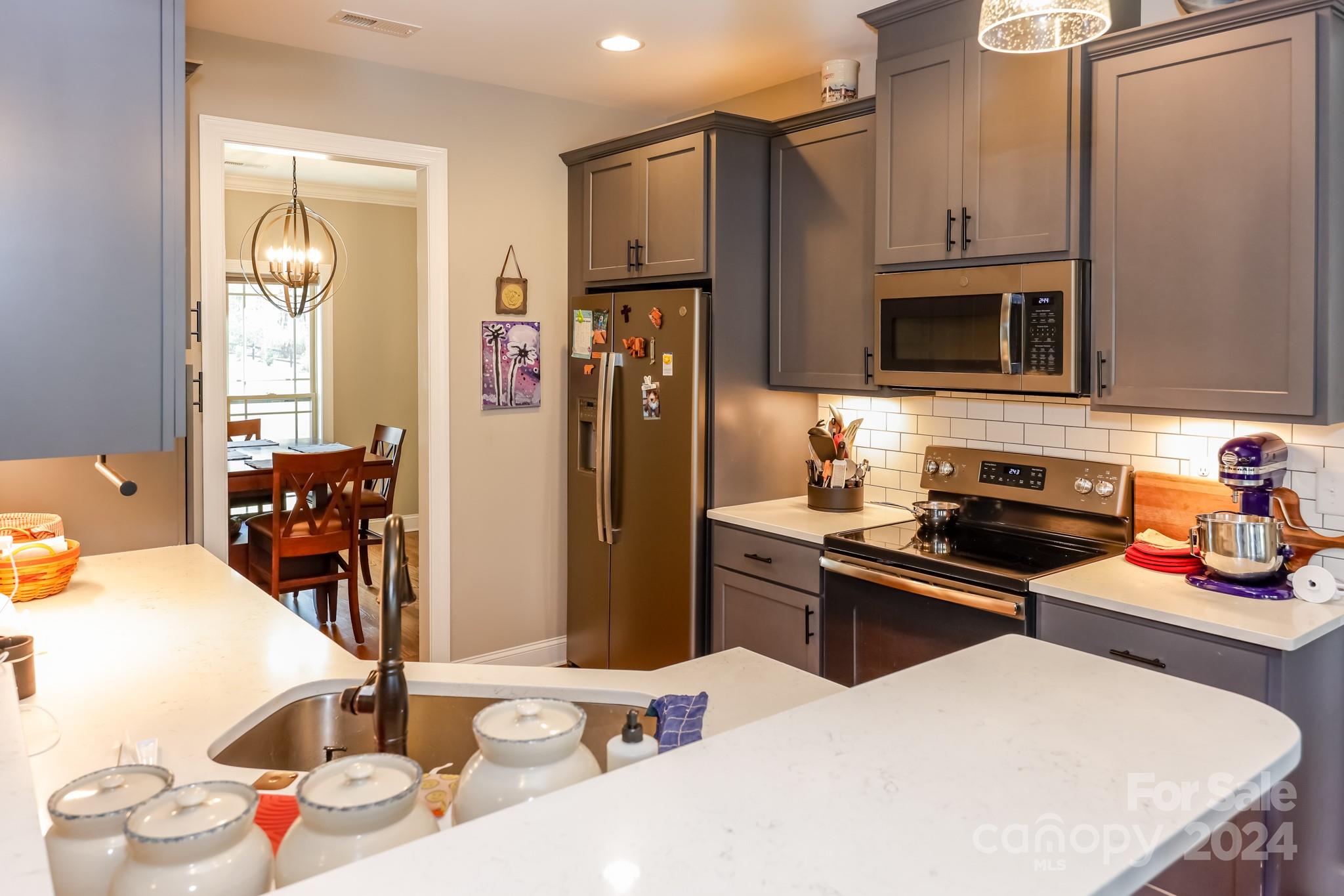 174 Spring Street Spindale, NC 28160 - Photo 7 of 30 a kitchen with stainless steel appliances kitchen island granite countertop a sink refrigerator and microwave
