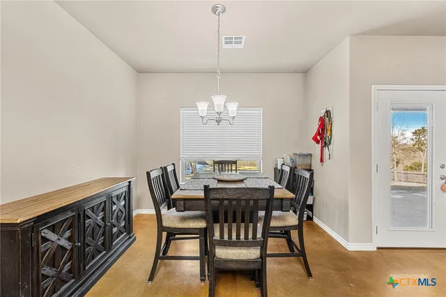 a view of a dining room with furniture and chandelier