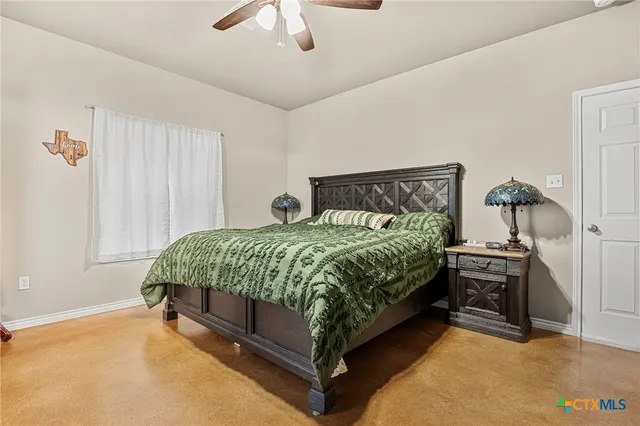 a bed sitting in a bedroom next to a window and a chandelier