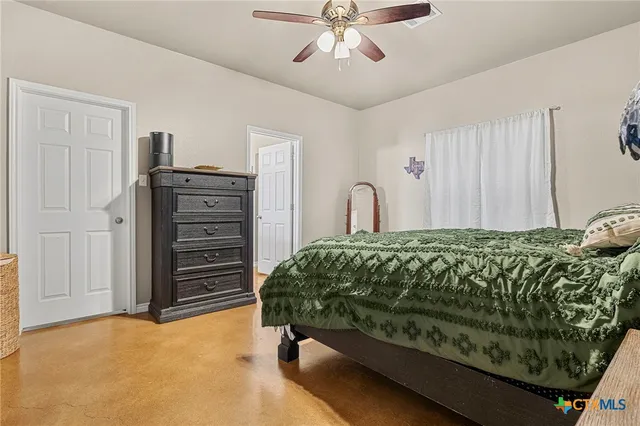a bed sitting in a spacious bedroom next to a window