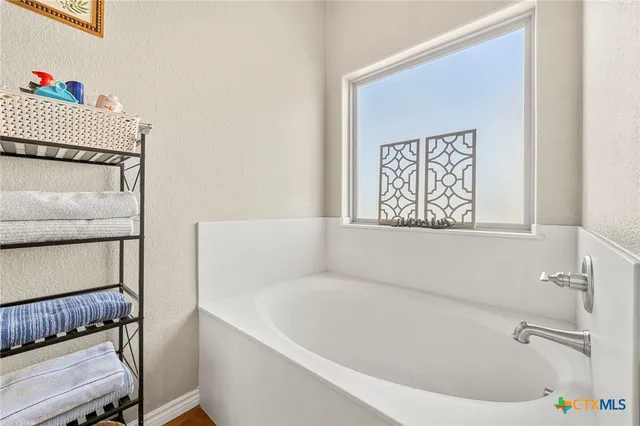 a bathroom with a bathtub and a window