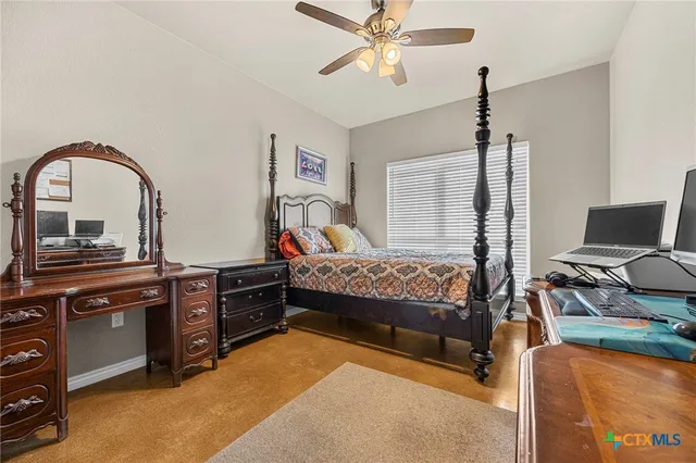 a bedroom with a bed and a flat tv screen on the dresser
