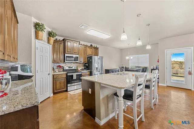 a kitchen with a sink a kitchen island and stainless steel appliances