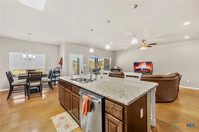 a kitchen with a stove a kitchen island a dining table and chairs with wooden floor