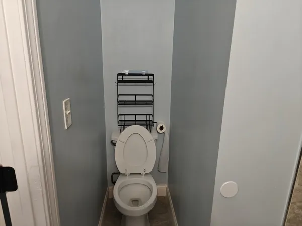 a white toilet sitting next to a shower
