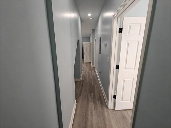 a view of a hallway with wooden floor