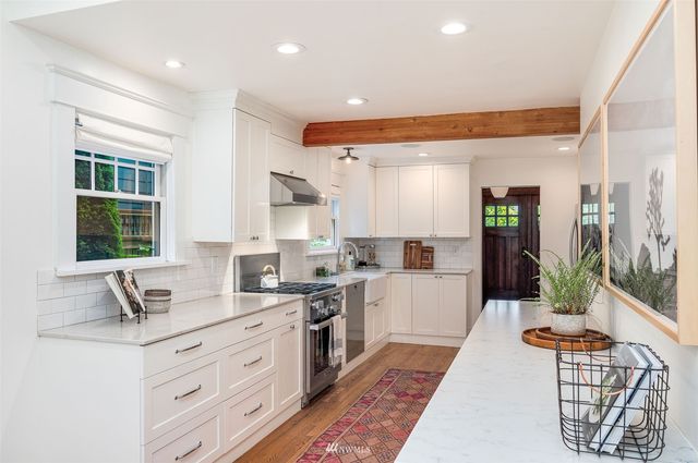 a kitchen with stainless steel appliances kitchen island granite countertop a sink stove and cabinets