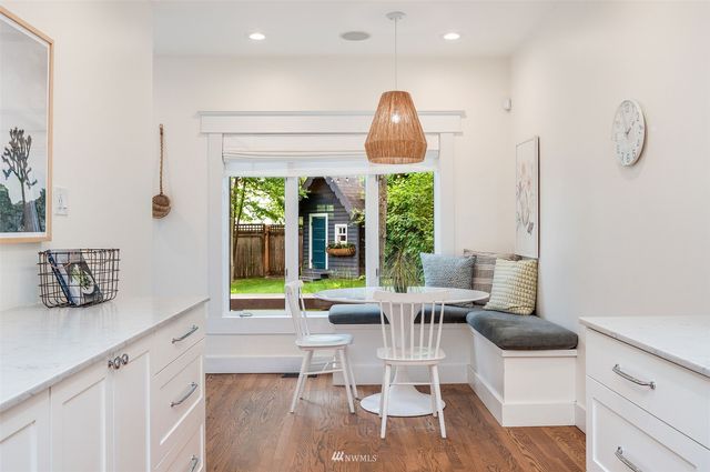 a kitchen with stainless steel appliances a table chairs and a large window
