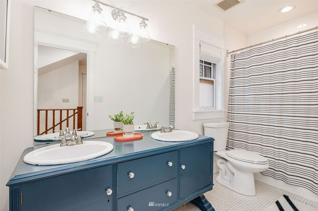 a bathroom with a sink double vanity and a toilet