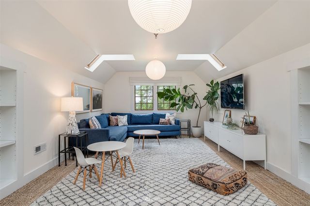 a living room with furniture a flat screen tv and a large window