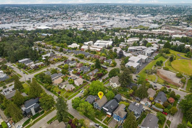 an aerial view of residential houses with outdoor space and trees