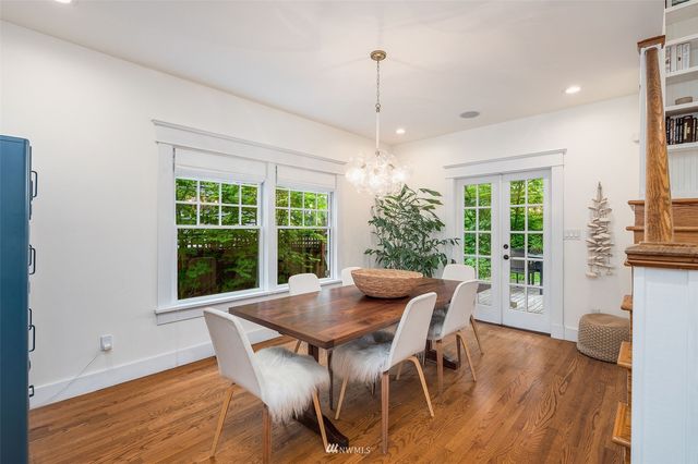 a dining room with furniture a chandelier and wooden floor