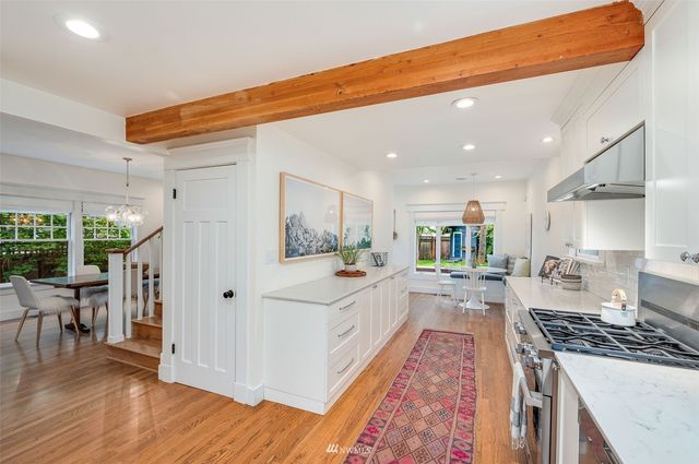 a large kitchen with stainless steel appliances granite countertop a stove and a view of living room