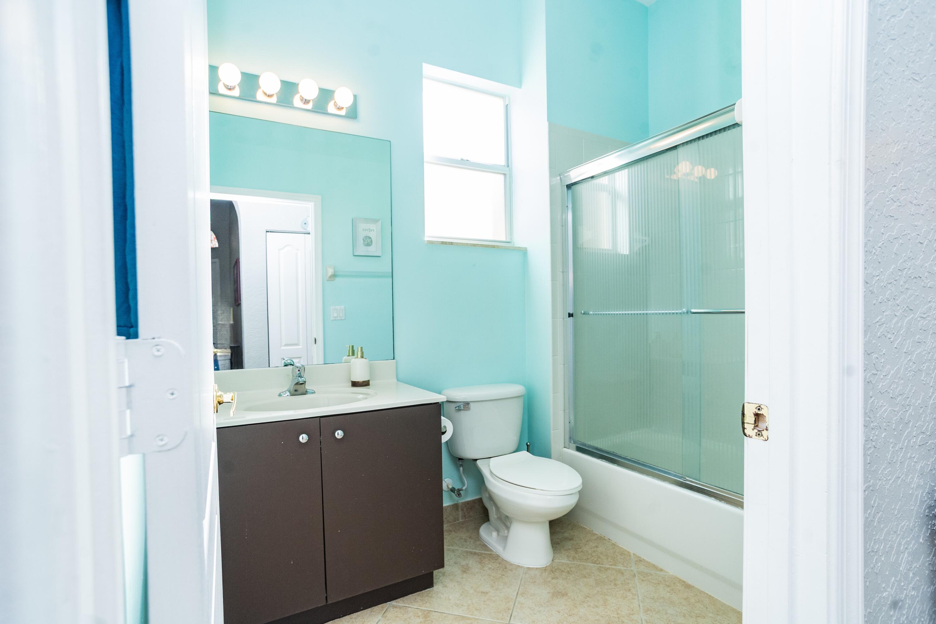 6020 Spring Lake Terrace Fort Pierce, FL 34951 - Photo 22 of 39 a bathroom with a toilet a sink and mirror