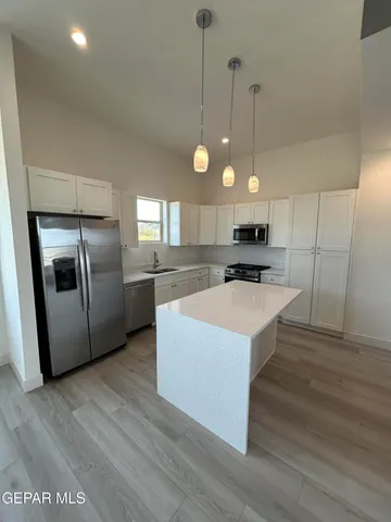 a large open kitchen with a refrigerator a stove top oven a sink and dishwasher