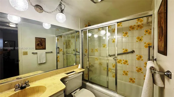 a bathroom with a shower sink vanity mirror and toilet