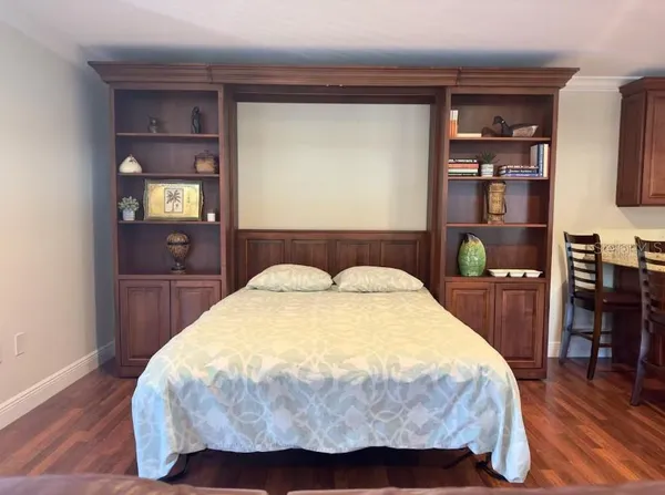 a bedroom with a bed and wooden floor