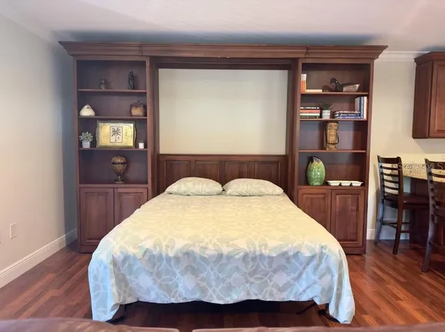 a bedroom with a bed and wooden floor