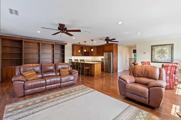 a living room with furniture a ceiling fan and a rug