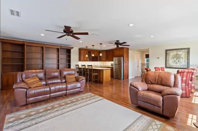 a living room with furniture a ceiling fan and a rug