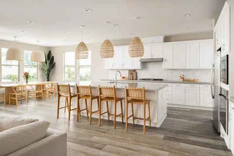 a living room with stainless steel appliances granite countertop a couch and a view of living room