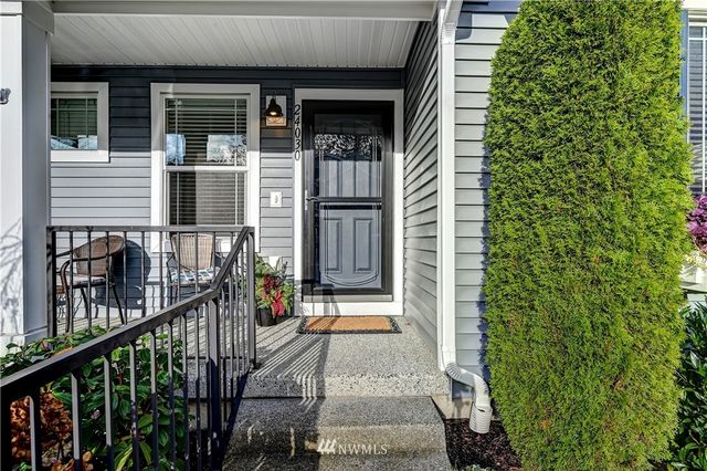 a view of a house with large windows and flower plants