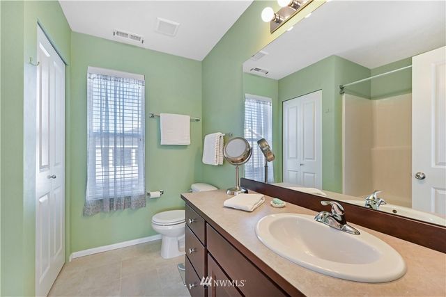a bathroom with a double vanity sink toilet and a mirror
