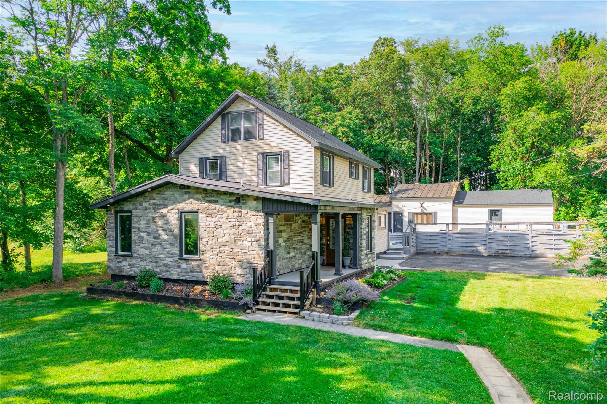 Stone and siding exterior with dark framed windows and shutters