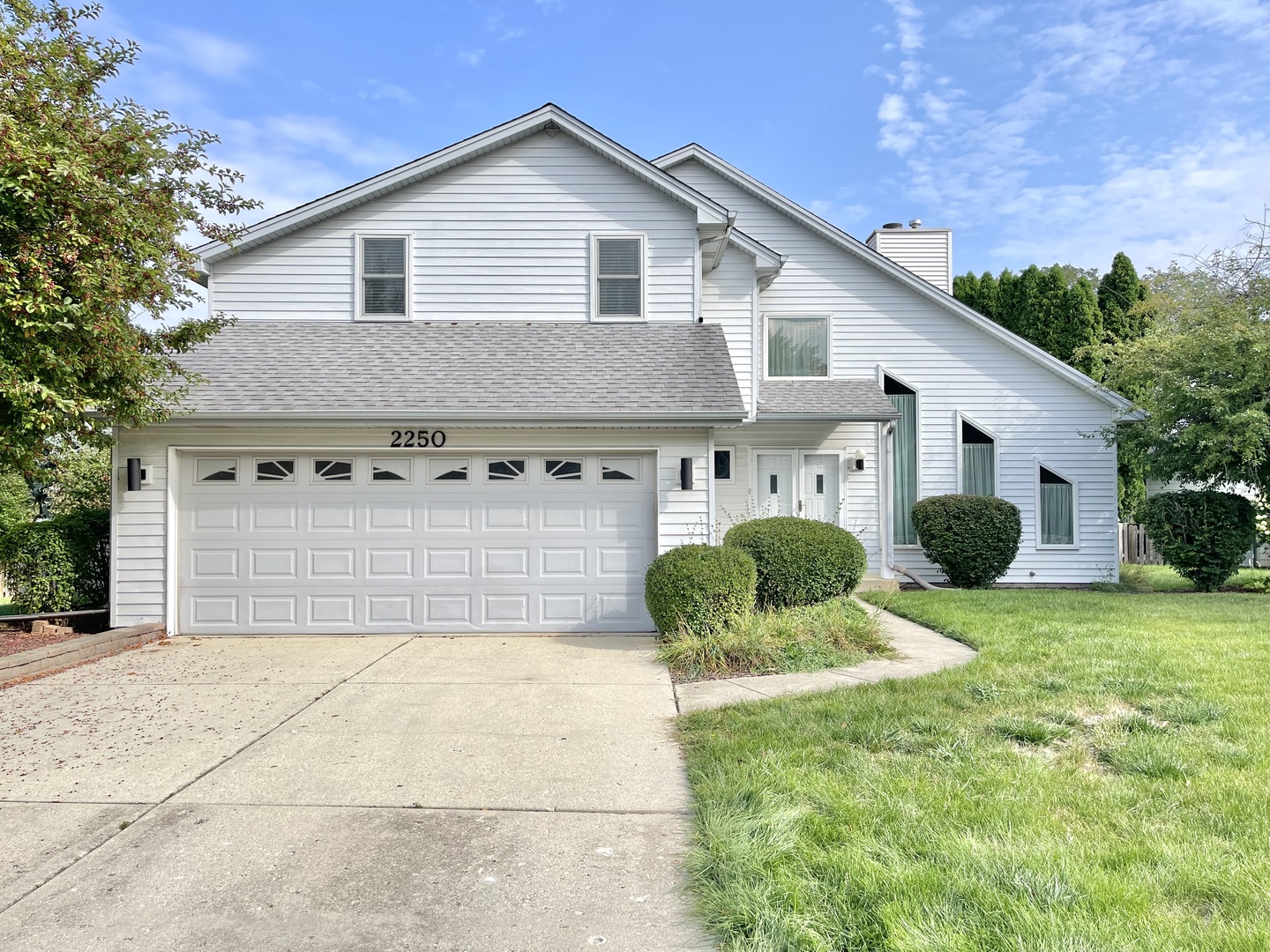 a view of a house with a yard and potted plants