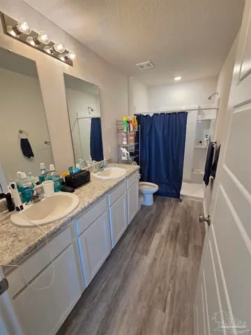 a bathroom with a sink vanity granite tub and a mirror