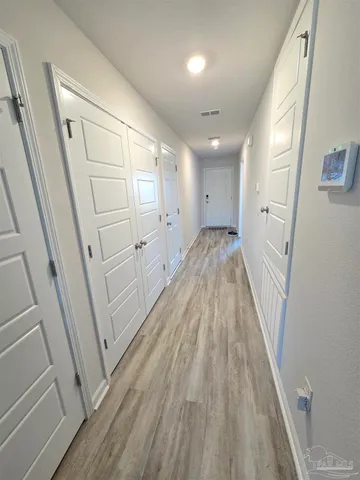 a view of a hallway with wooden floor and staircase