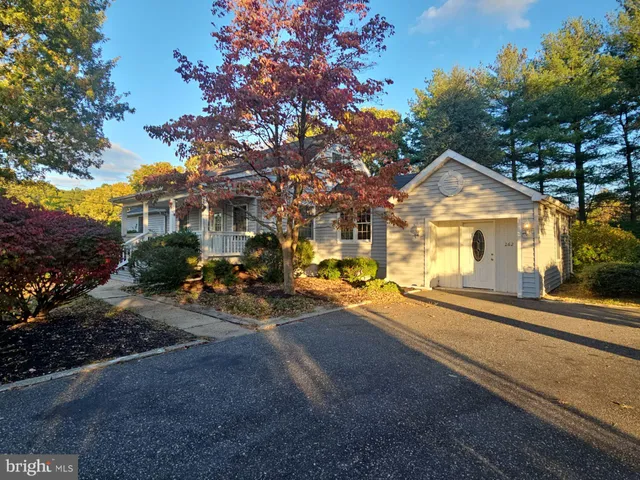 a view of a house with large windows and a tree