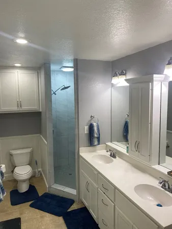 a bathroom with a double vanity sink toilet and a mirror
