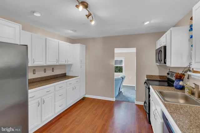 a kitchen with granite countertop a sink stove and cabinets