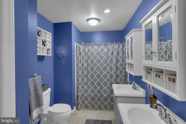 a white toilet sitting next to a bathroom sink and a shower