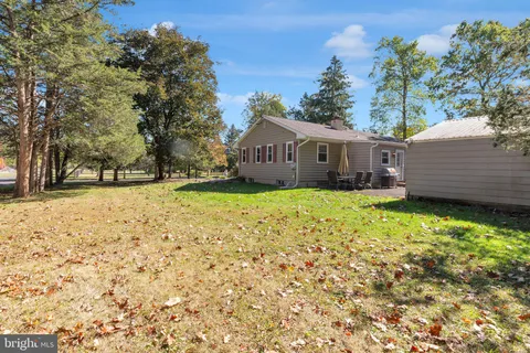 a view of a house with a large tree and a yard