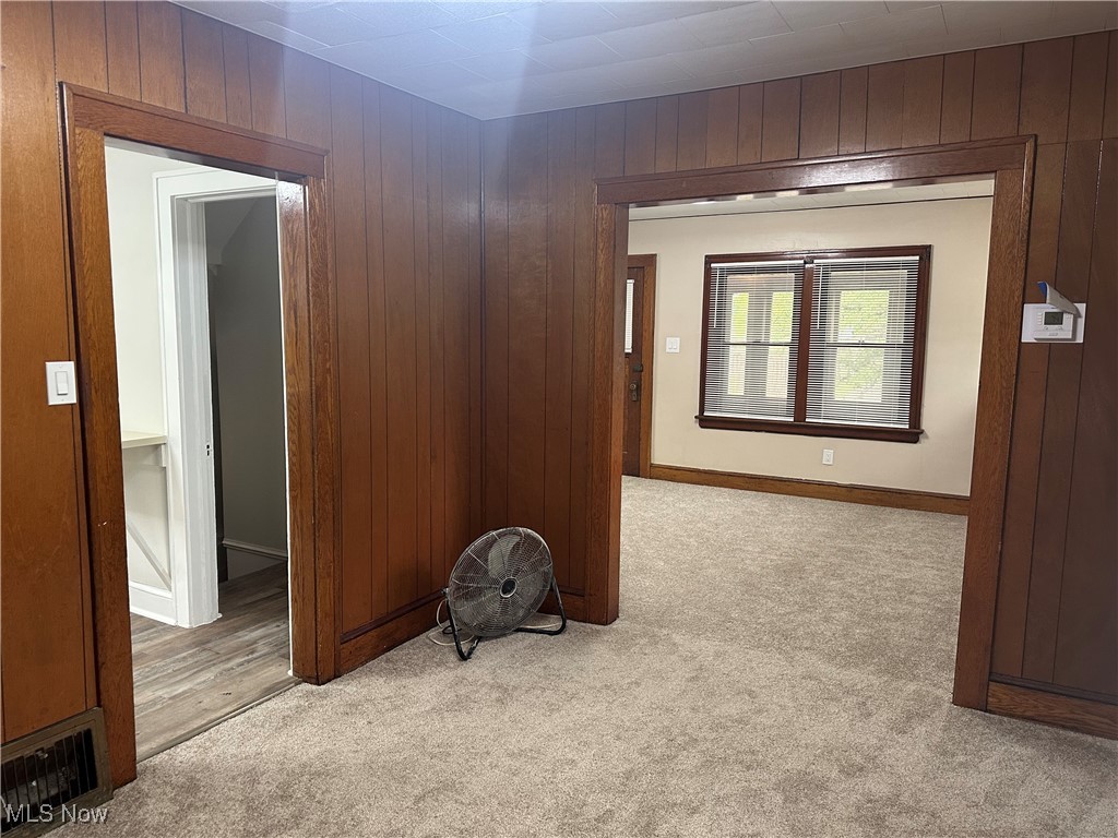 835 Inman Street Akron, OH 44306 - Photo 9 of 25 Unfurnished room featuring wooden walls and light colored carpet