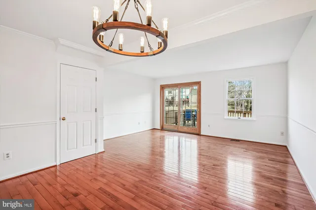 an empty room with window and wooden floor