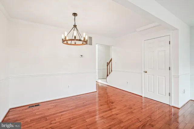 a view of empty room with wooden floor and ceiling fan