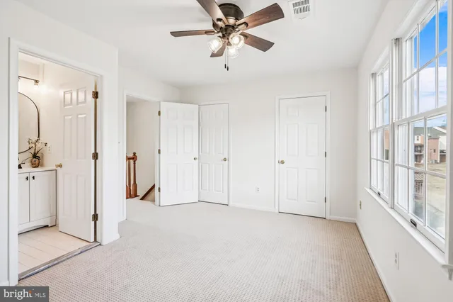 a view of a livingroom with a chandelier fan and a window