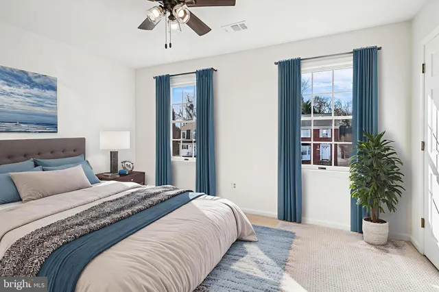 a bedroom with a large bed and a potted plant