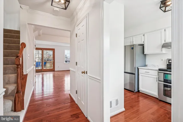 a view of a kitchen with a refrigerator a stove top oven and cabinets