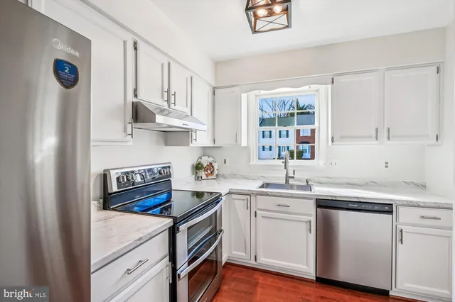 a kitchen with cabinets appliances a sink and a window
