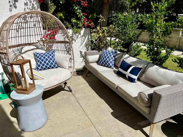 a view of a patio with couches table and chairs and potted plants