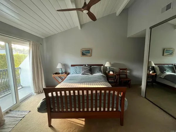 a bedroom with a bed window and a chandelier